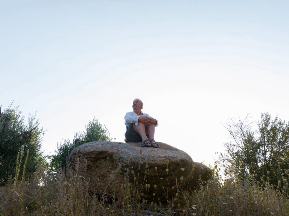 Michel Delvosalle assis sur un rocher